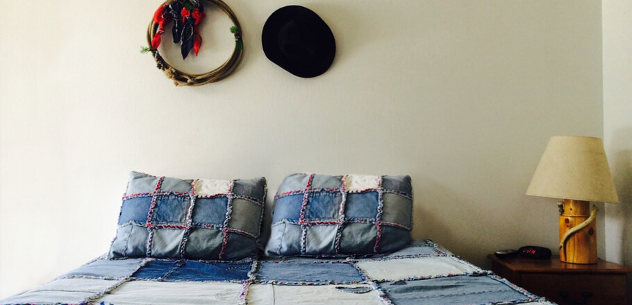 Single queen bed with a home-made denim quilt
