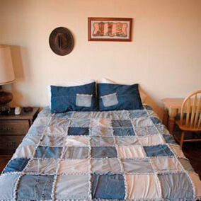 A cowboy hat and Western photo hanging above a single bed
